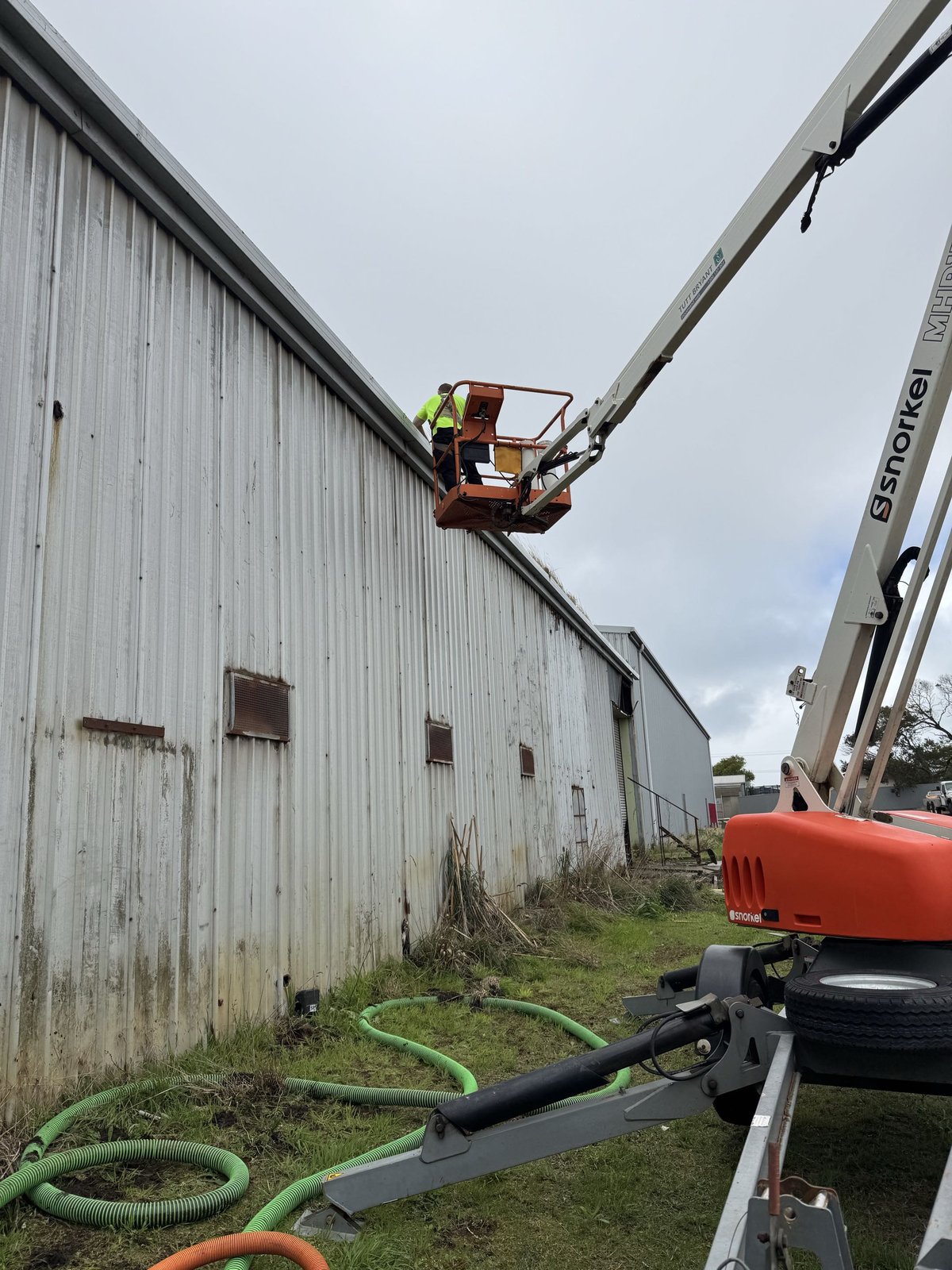 Gutter cleaning using a boom lift on a commercial building
